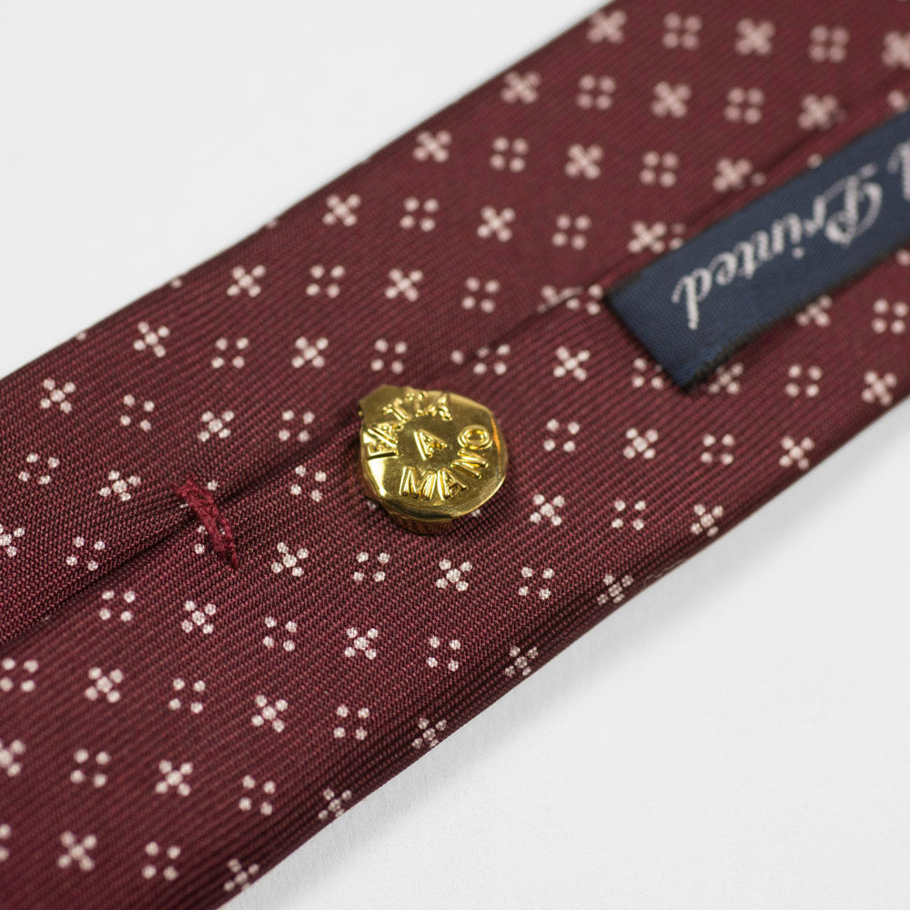 Burgundy silk tie, white hand-printed neat motifs, self-tipped