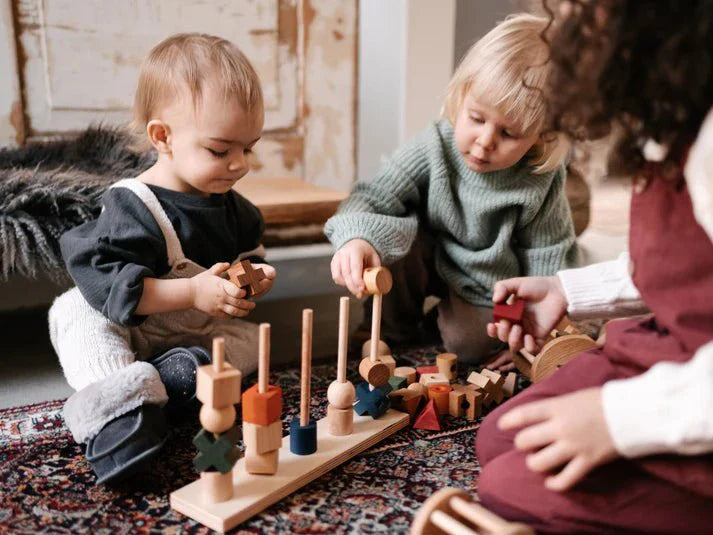 Children play with the Montessori Stacking Toy - Rainbow