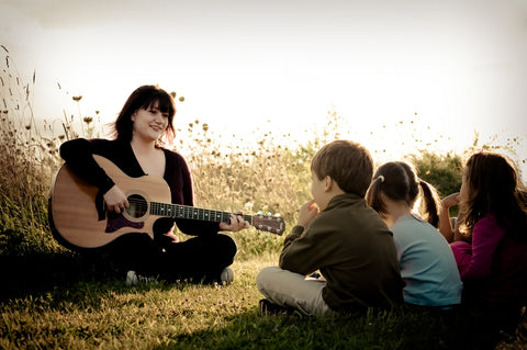 Charlie Hope in the field singing to children