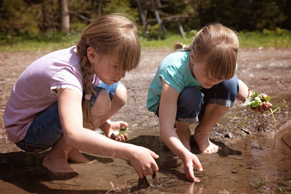 Girls playing in a mud puddle