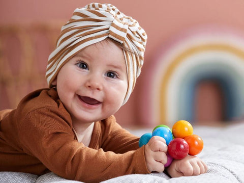 child with haba clutching toy at blue otter toys