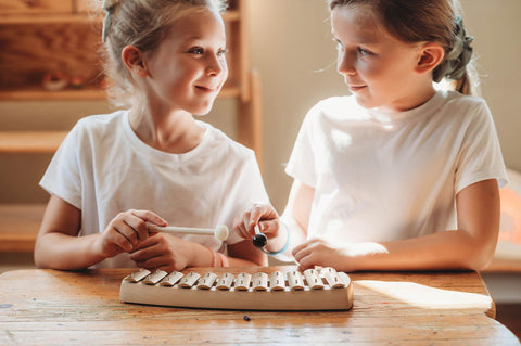 Two girls playing an auris glockenspiel