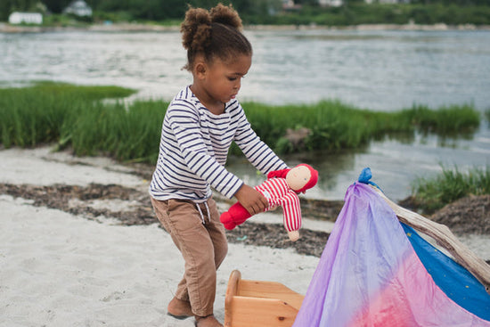 Girl Playing with Keptin-Jr Doll on Beach