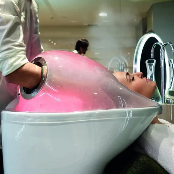 A stylist washing a client's hair in the Alu Green Wash basin