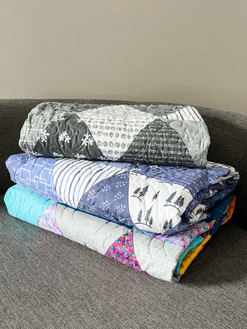 Photograph of a stack of folded quilts.