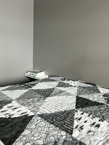 Photograph of a quilt on a bed.