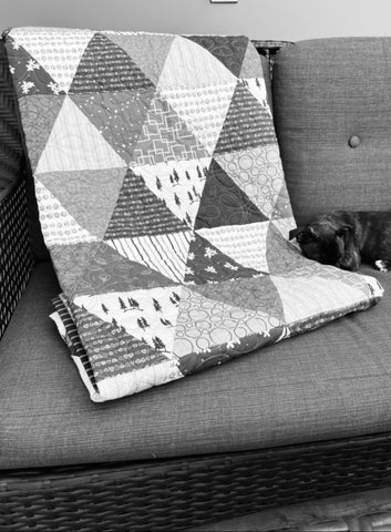 Photograph of a quilt draped on a couch.