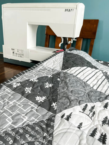 Photograph of a quilt with a sewing machine.