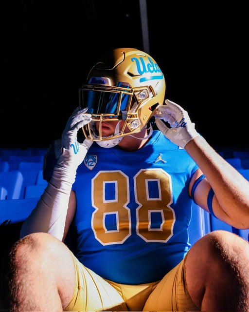 Jonah Coleman standing with a football between both hands.