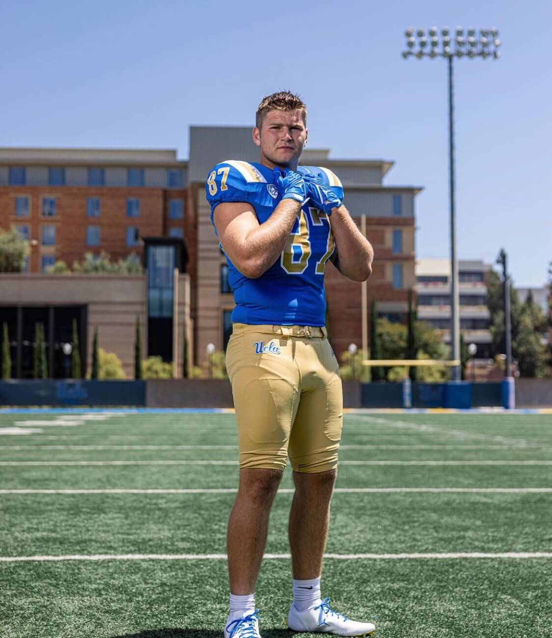 Jonah Coleman standing with a football between both hands.