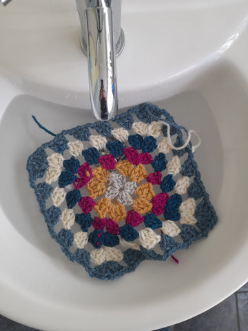 A granny square soaking in a basin