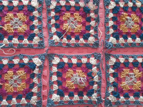 6 flat granny squares blovked out on a blocking mat