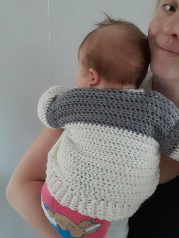 Lovechunk baby sweater modelled on a baby. Easy crochet cardigan pattern pdf. Quick crochet makes for babies and toddlers.