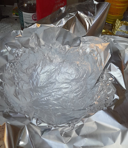 a colander wrapped in tin foil