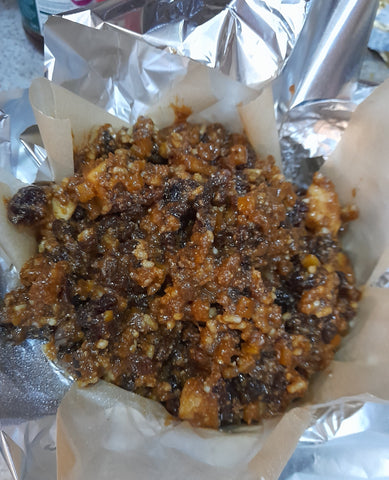 christmas pudding mixture being laid into the foil and baking parchment