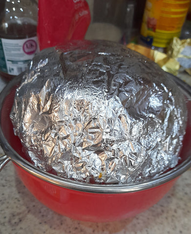 wrapped christmas pudding in a sieve