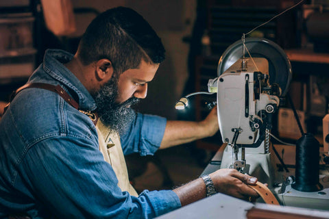 Man working on leather on a leather sewing machine