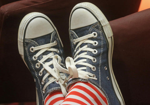 Blaue Chucks mit weißer Sohle, rot-weiß geringelte Socken