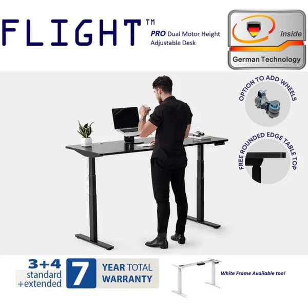 Flight Pro Dual Motor Height Adjustable Desk - Showcasing German technology, this height-adjustable table from Flight offers a sturdy, ergonomic workspace with a dual motor for smooth adjustments. Featured is a professional man at the desk, highlighting the desk’s sleek design and functionality, including the option to add wheels for mobility and a free-rounded edge tabletop for comfort.
