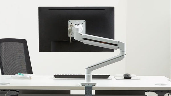 Sleek white ergonomic monitor arm on a clean desk setup in Singapore.