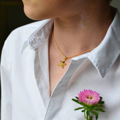 Boy wearing a gold starfish necklace