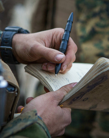 a man writing in a notebook with a pen