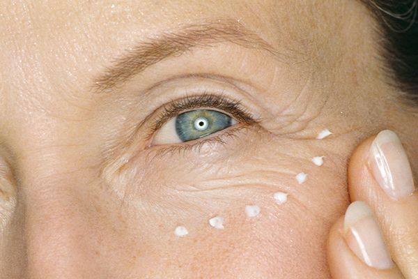 Mature woman applying eye cream