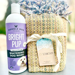 Bright Pup Dog Wash Bottle next to Colorful Tan Solwoven Towel
