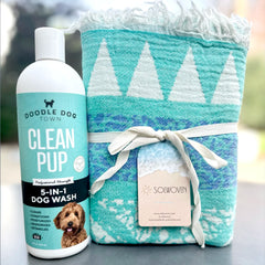 Clean Pup Dog Wash Bottle next to Blue Solwoven Towel
