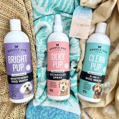 Doodle Dog Town Grooming Bottles lying on three Solwoven towels