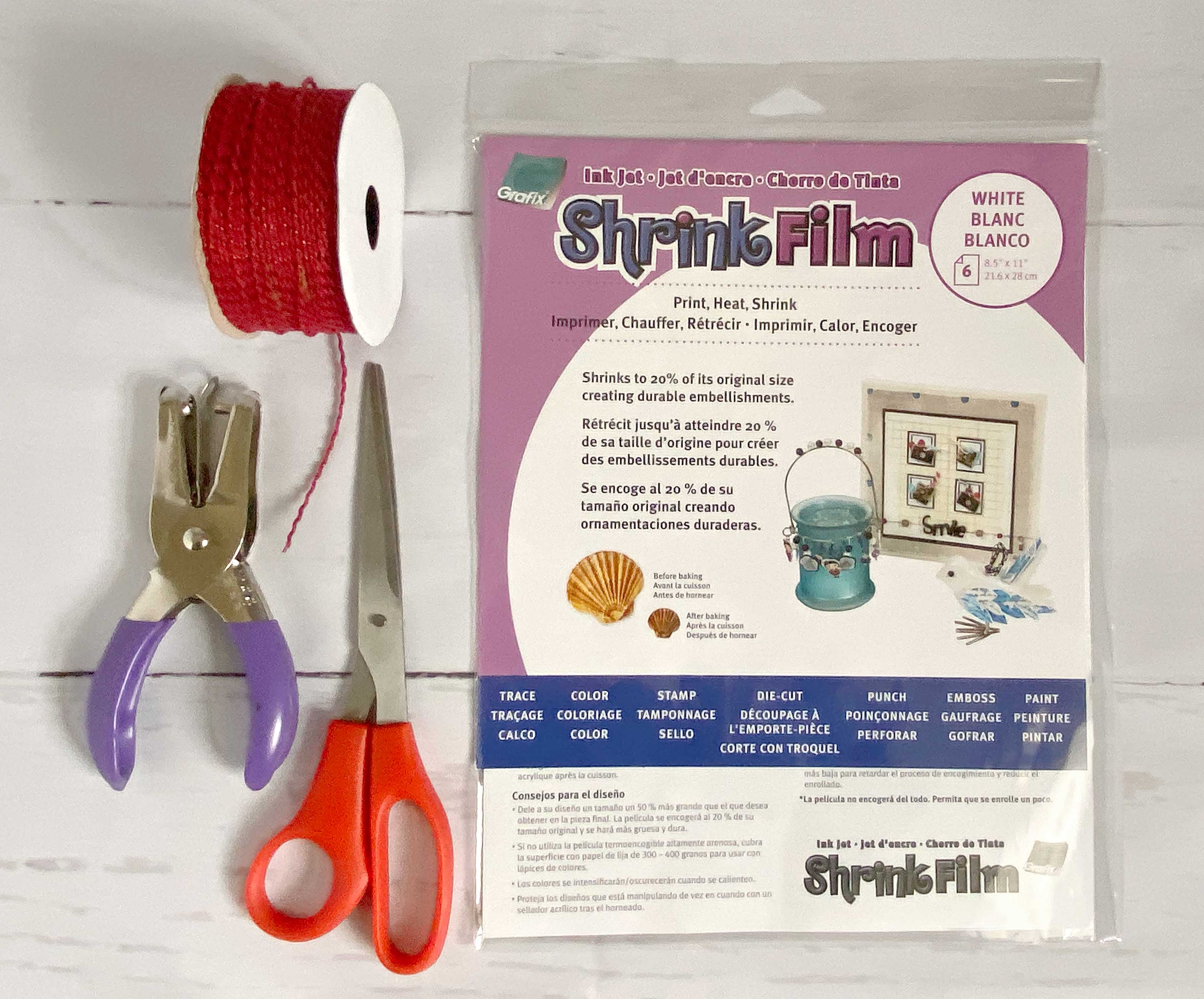 Collage of Shrink film, scissors, hole puncher and red ribbon