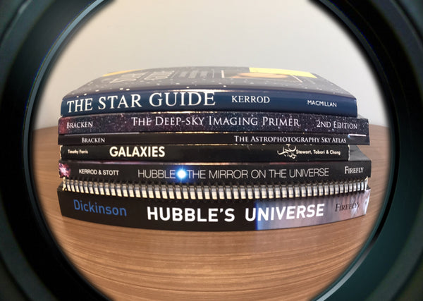 A stack of astronomy books viewed through a fisheye lens
