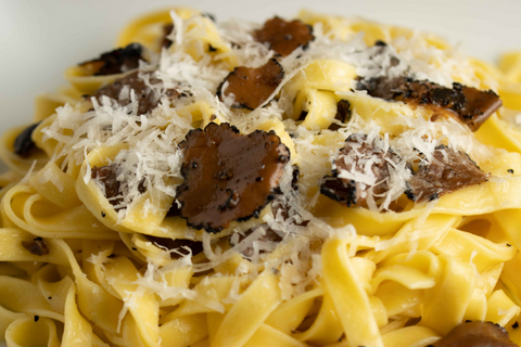 Serve tagliatelle pasta and garnish with extra truffle and parmigiano reggiano cheese
