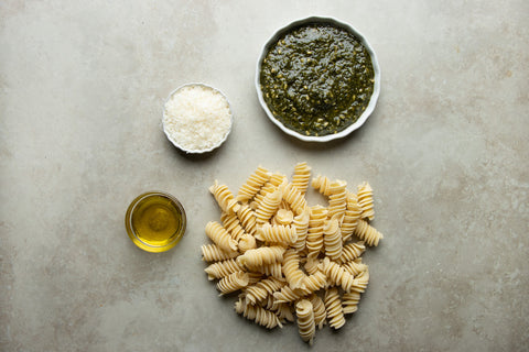 Ingredients to make a rigatoni pasta with pesto sauce
