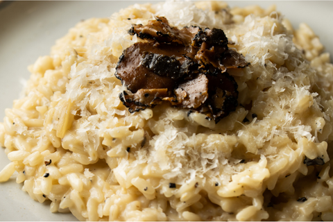 Serve and garnish truffle risotto with more cheese and black truffle slices