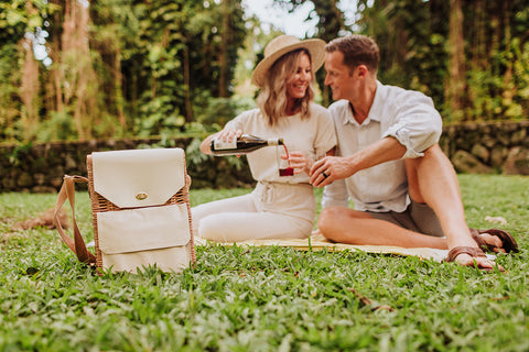 couple on a picnic with wine and cheese basket