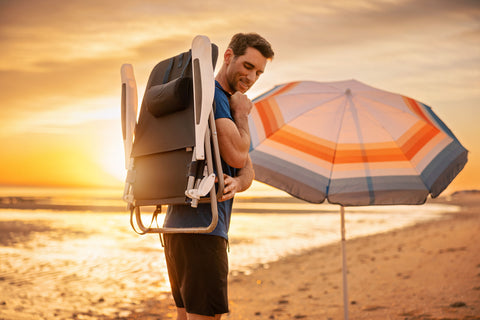 man at beach with an umbrella and beach chair from Oniva a Picnic Time brand