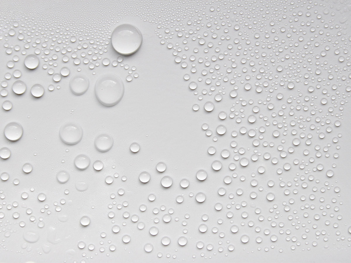 Large water droplets sitting on a white background.