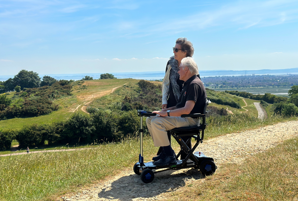 A man on a folding mobility scooter through the English countryside