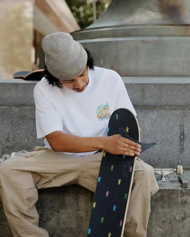 Skateur appliquant du ruban adhésif Grizzly sur le plateau de planche à roulettes