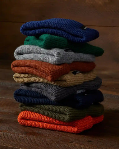 Beanies In Different Colors Stacked On Top Of Each Other