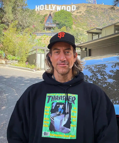 Brian Anderson Wearing A Thrasher Hoodie In Front Of The Hollywood Sign