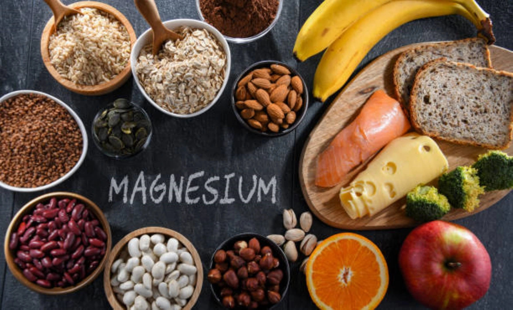 magnesio glicinato; comida sobre un fondo negro y la palabra magnesio escrita con gis.