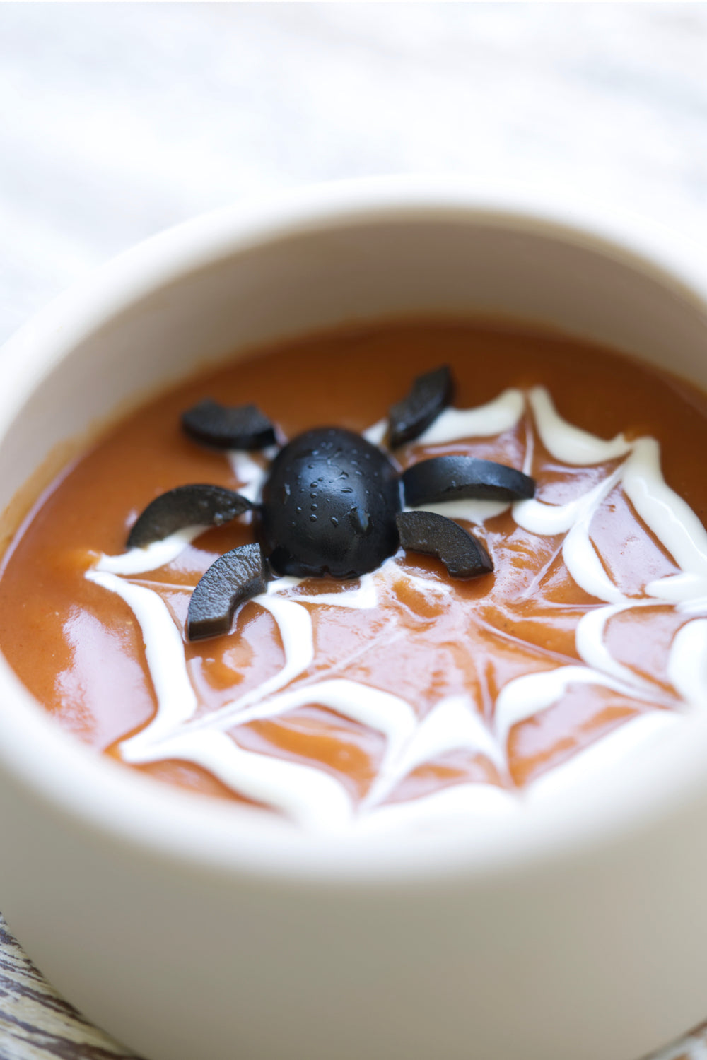 tomato soup with spider web decoration for halloween