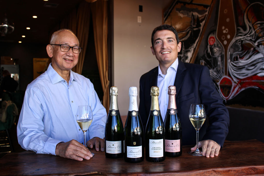 Willie Wond and Champagne Palmer Export Director Raymond Ringeval pose with four bottles of Champagne