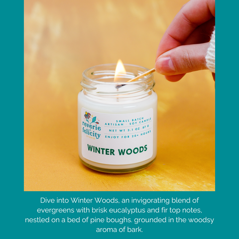 A hand with a lit match lights a Winter Woods handmade scented soy candle featuring notes of eucalyptus, pine, and patchouli from Reverie + Felicity Studio
