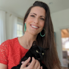 Erin Hils of Reverie + Felicity Studio holding her cat Lulu and smiling at the camera