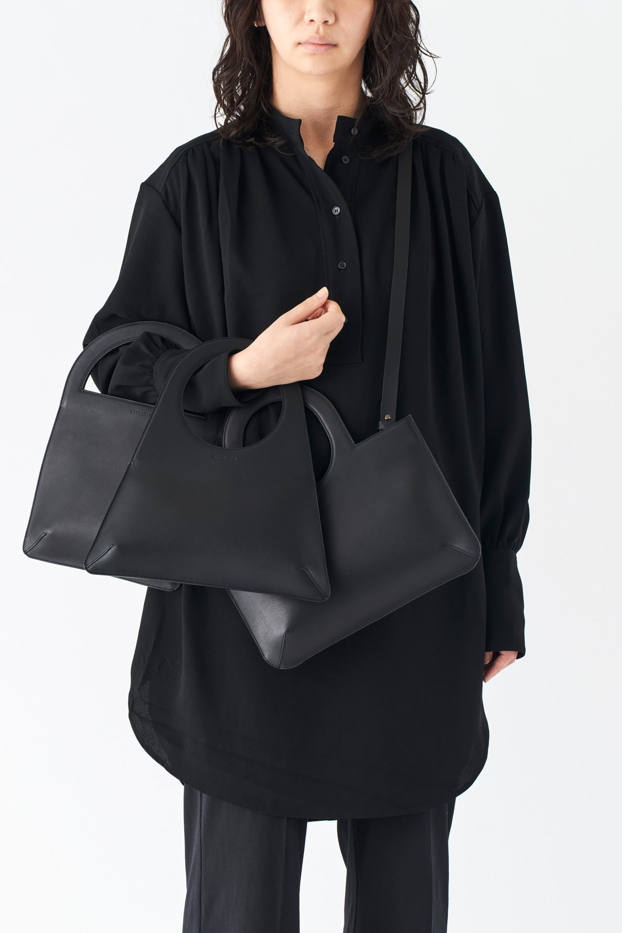 シンプルなレザーのショルダーハンドバッグとモードスタイルの女性