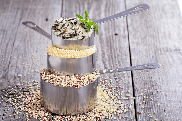 Measuring cups with different sizes and different types of grains and flour in them