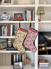 Two stockings hanging off library bookshelves with the names 'Molly' and 'Jeremy'